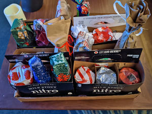 Four six packs of beer, each wrapped in different wrapping paper